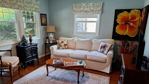 Un salon chaleureux avec un canapé, un fauteuil, une table basse et une cheminée.