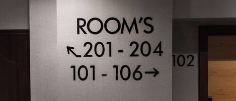 A wall sign indicating room numbers 201-204 and 101-106 for a hotel.
