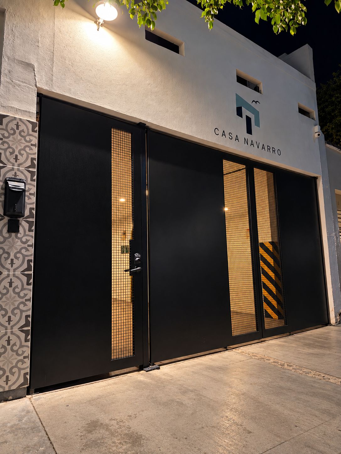 Une façade moderne avec une grande entrée, une porte bien visible et une enseigne indiquant « CASA NAVARRO ».