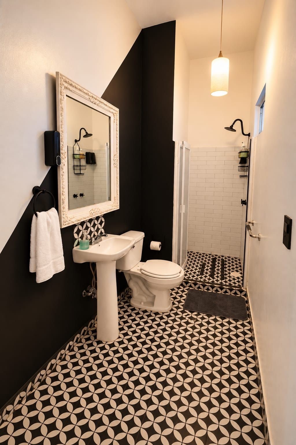 A bathroom with a white sink, toilet, and a mirror with a decorative frame. The floor has a black and white geometric pattern.