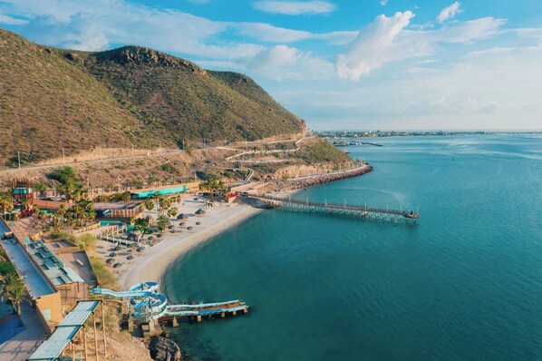A coastal resort with a beach, a pier, and a mountainous backdrop. - Casa Navarro (La Paz)