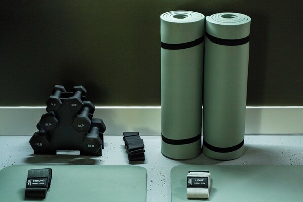 A fitness equipment display with dumbbells, a weight stack, and resistance bands.