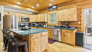Une cuisine moderne avec des meubles en bois, des appareils électroménagers en acier inoxydable et un îlot central.