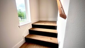 Un escalier avec des marches en bois et une fenêtre en haut.