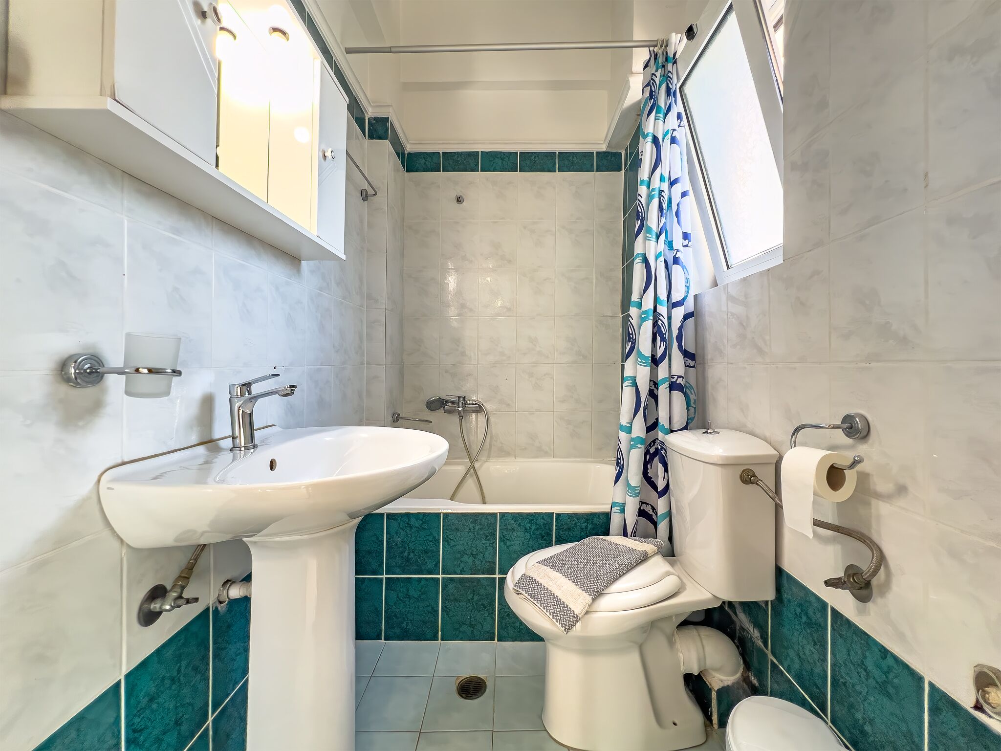 Un baño con lavamanos, inodoro y bañera.