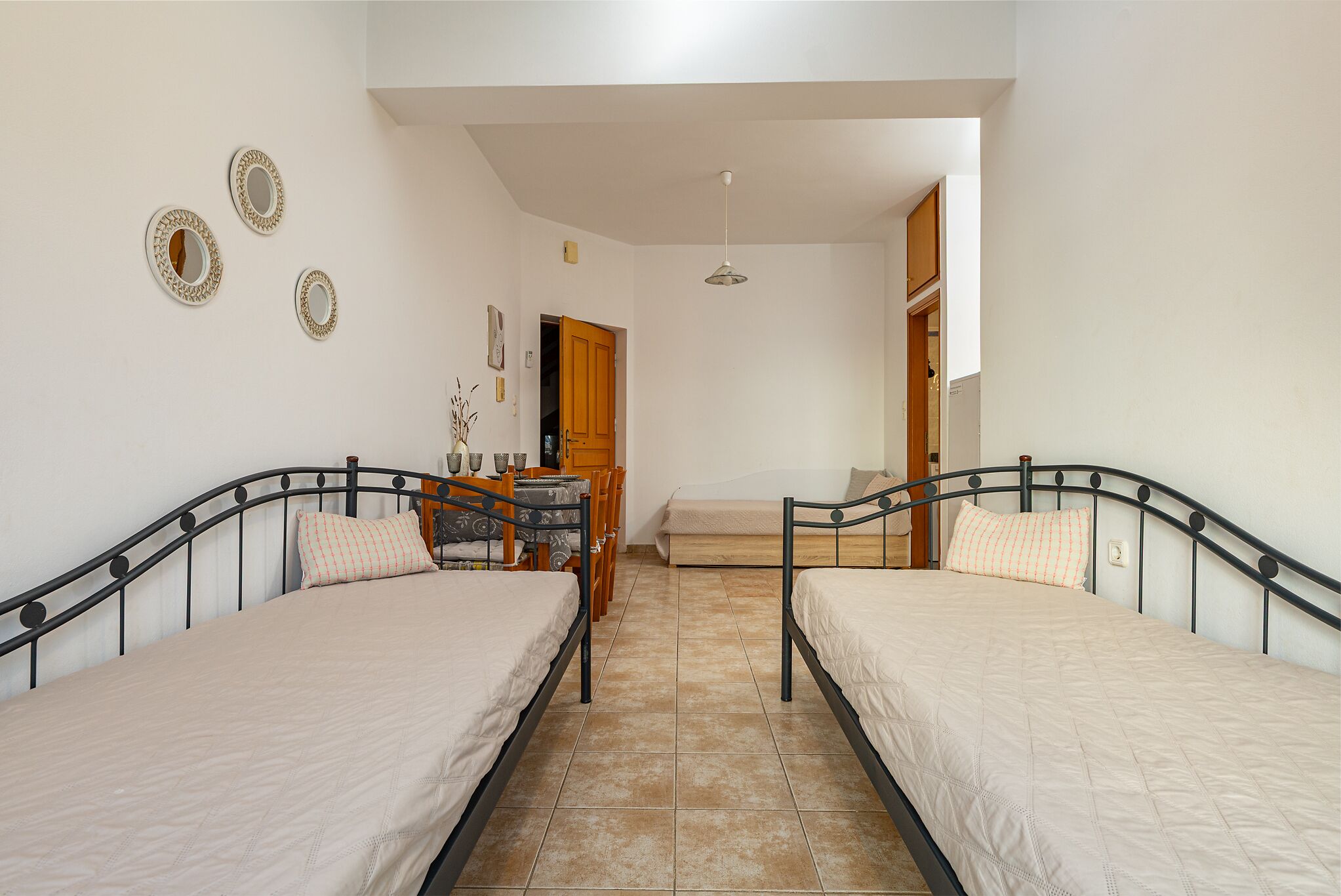 A bedroom with two beds, a desk, and a chair.