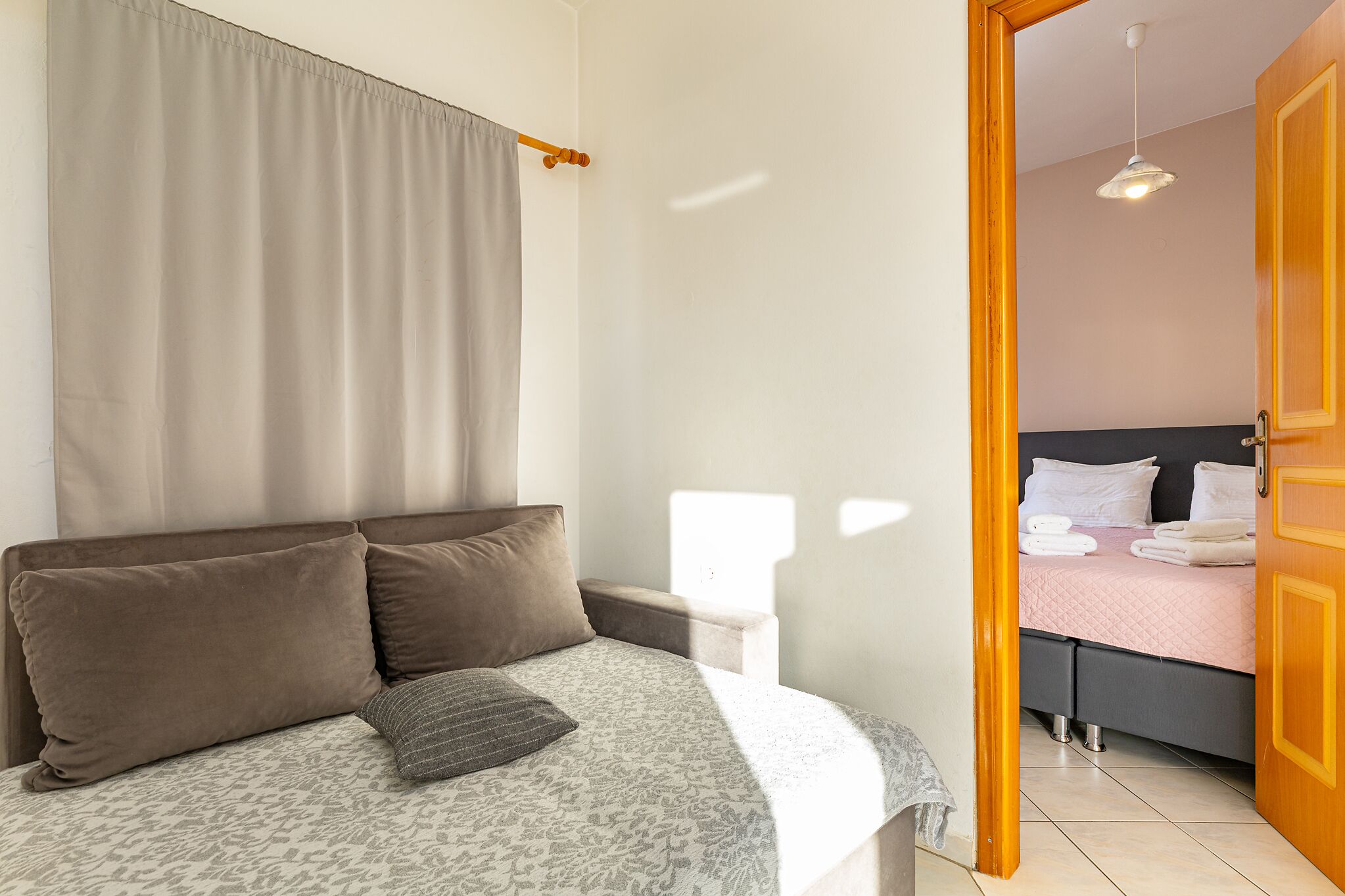 Une chambre à coucher avec un lit, une table de chevet et une porte donnant sur une autre pièce.