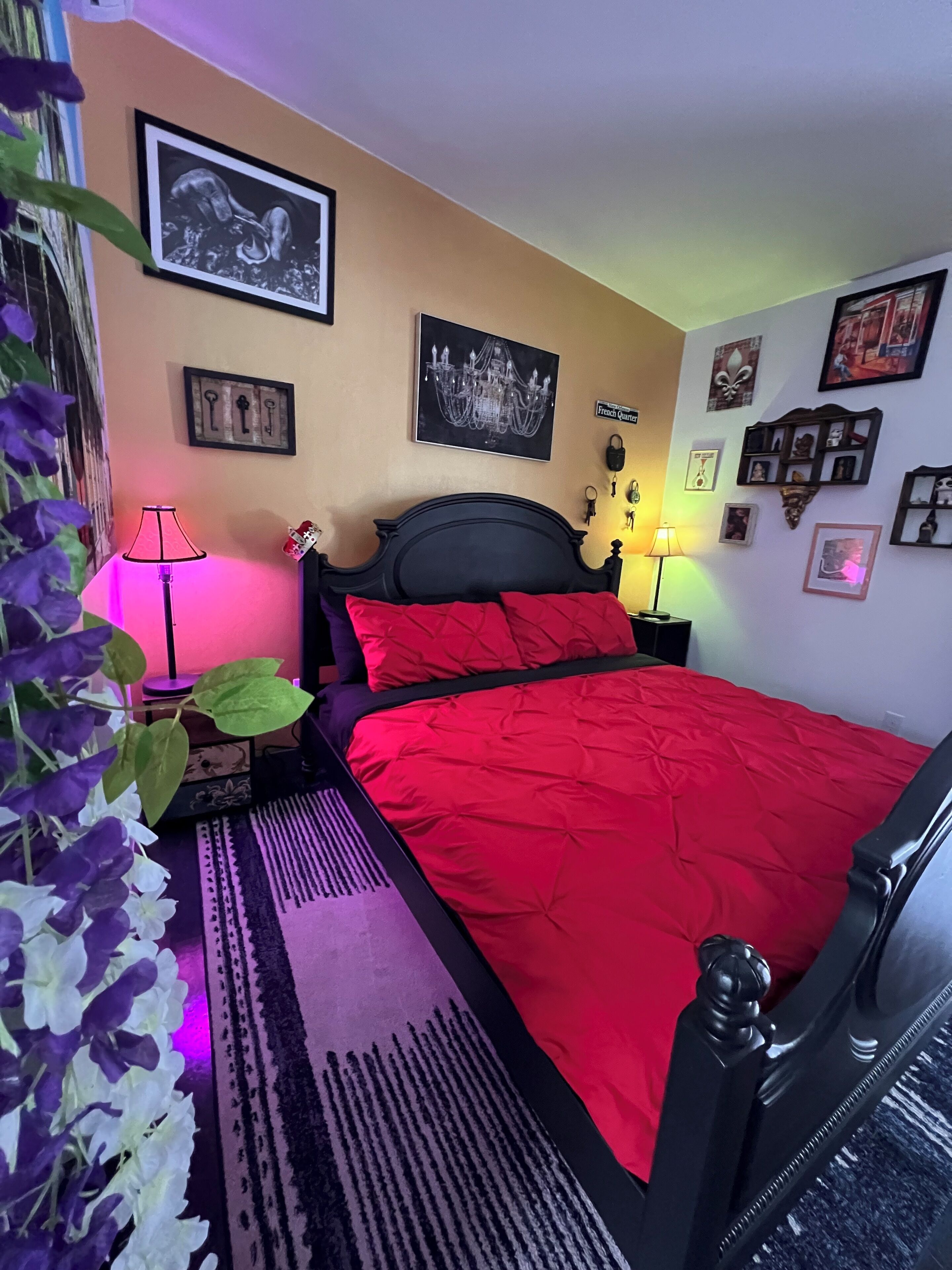 Une chambre à coucher avec un lit, une table de chevet, une lampe et des éléments décoratifs sur les murs.