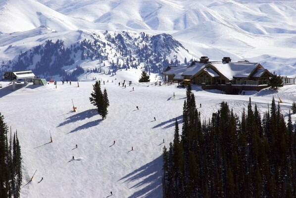 A ski resort with multiple lodges, ski slopes, and a mountainous backdrop.