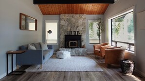 Una sala moderna con chimenea de piedra, techo de madera y ventanas amplias.