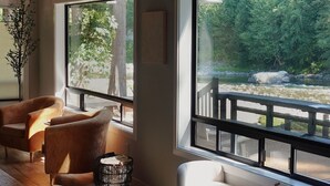 Una sala de estar moderna con ventanas amplias, techo de madera y un sofá.