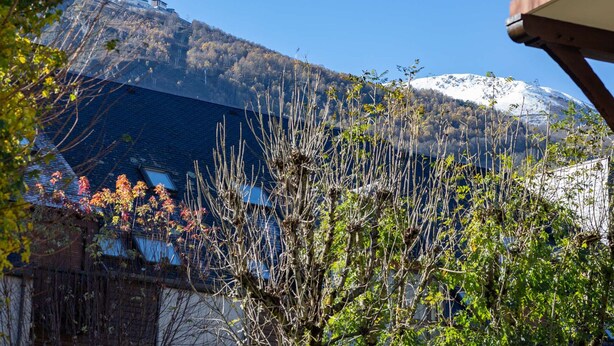 A mountain with a snow-capped peak, a clear blue sky, and a building with a balcony in the foreground. - Apartment for 6 in Vielle-Aure - Near cable car, private parking (Vielle-Aure)