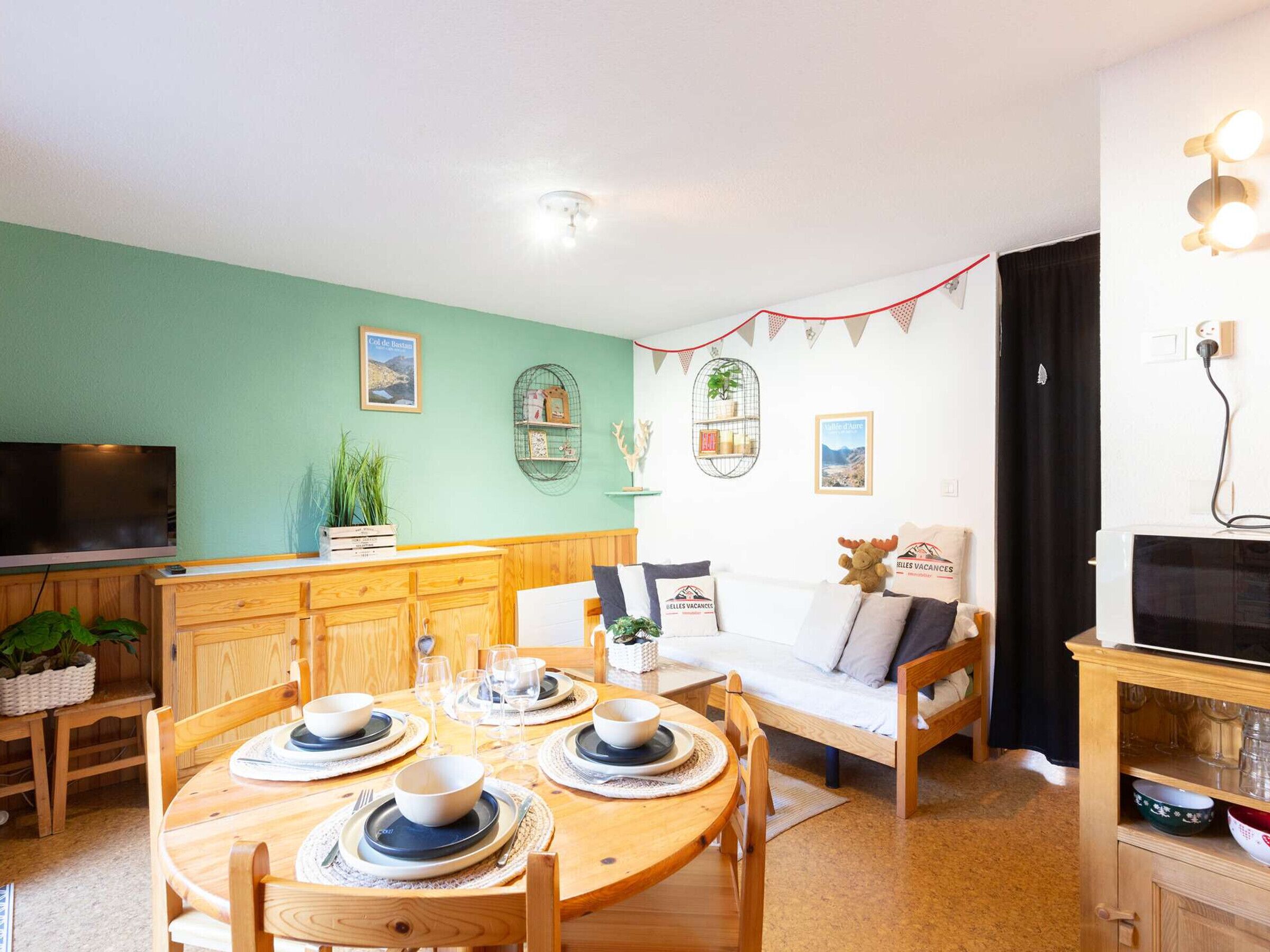 Un salon chaleureux avec un coin repas, des meubles en bois et un téléviseur.
