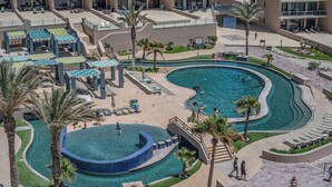 Ein Resort mit großzügiger Poolanlage, mehreren Liegebereichen und einer gepflegten Landschaft mit Palmen.