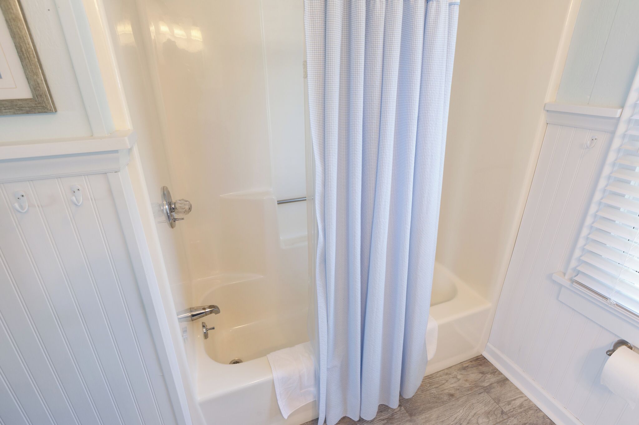Une salle de bain avec une baignoire, un rideau de douche et un porte-rouleau de papier toilette.