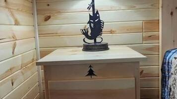 Een houten nachtkastje met een lamp en een lade.