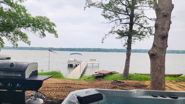 Eine Uferlandschaft mit Grill, Whirlpool und einer anlegenden Mole.
