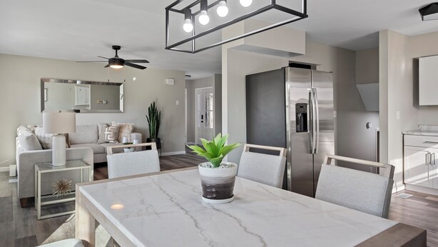 A modern kitchen with a built-in refrigerator, a dining area with a marble table, and a ceiling fan. - Modern 5BR Sleeps 12 Fire Pit 85" TV Decatur (Decatur)