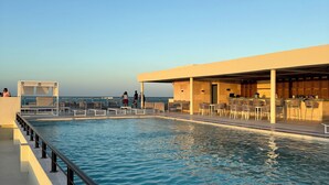 A pool area with a clear sky, a covered seating area, and a bar. - Sea and Sand (Progreso)