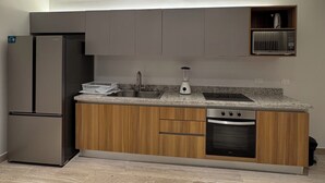 A modern kitchen with a built-in refrigerator, a microwave, a sink, and wooden cabinets. - Sea and Sand (Progreso)