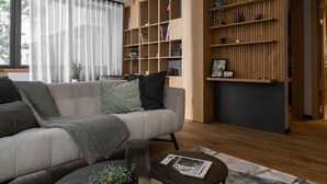 Un salon moderne avec un canapé, une table basse et des étagères en bois intégrées.