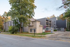 Een modern gebouw met een parkeerplaats, een verbodsbord voor parkeren en een voetpad.