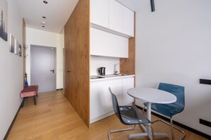 A compact kitchen with a dining area, a small seating nook, and a wooden partition. - Dzintari Light-Filled Studio next to Sea & Park (Jurmala)