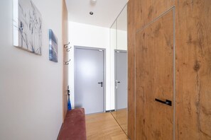 A hallway with a wooden bench, a door, and a wall-mounted artwork. - Dzintari Light-Filled Studio next to Sea & Park (Jurmala)