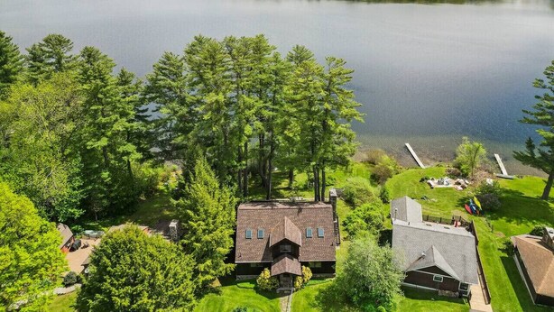 A lakeside property with a house, a dock, and a boat.