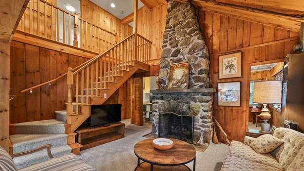 A wooden interior with a stone fireplace, a TV, and a staircase. - Stockbridge Landings | 3 Mins To Tanglewood (Stockbridge)