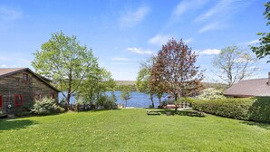A grassy yard with a wooden cabin and a lake in the background. - Stockbridge Landings | 3 Mins To Tanglewood (Stockbridge)
