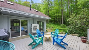 Eine Terrasse mit Gartenmöbeln, einem Grill und einer großen Klimaanlage.