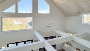 A modern interior with high ceilings, large windows, and a minimalist design.