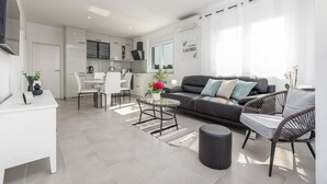 A modern apartment with a living area, kitchen, and dining space.
