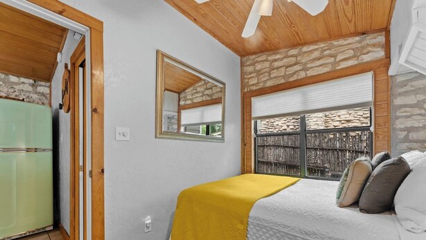 Una camera da letto con un letto, uno specchio, una finestra vista e una porta che dà su un'altra stanza.