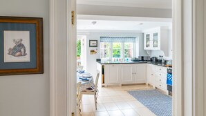 A kitchen with white cabinets, a black countertop, and a blue patterned rug. - Samphire,  Aldeburgh (Aldeburgh)