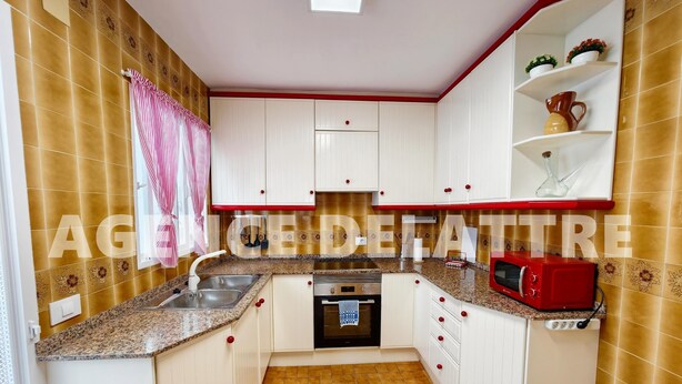 A compact kitchen with white cabinets, a granite countertop, a built-in oven, and a microwave. - Semi-detached Villa for Sale in Peníscola, Great Location (Peníscola/Peñíscola)
