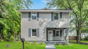 A two-story house with a front porch, a mailbox, and a small front yard. - Carolina Cottage Near Ft Jackson, 5Pts & Zoo! Sleeps 12-Spacious 4 bed/2.5 bath! (Columbia)