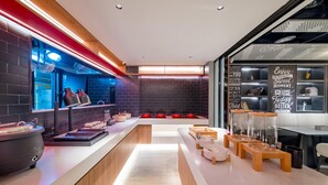 A modern kitchen with a long counter, red pots, and a chalkboard with motivational quotes. - Ibis Hotel (Beijing)