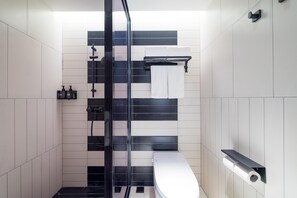 A modern bathroom with a glass-enclosed shower, a toilet, and a towel rack. - Ibis Hotel (Beijing)