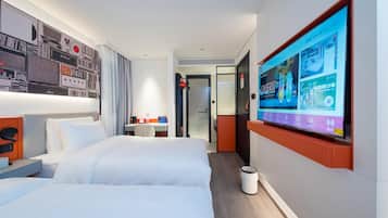 Habitación de hotel con una cama grande, un escritorio y un televisor en la pared mostrando un menú.
