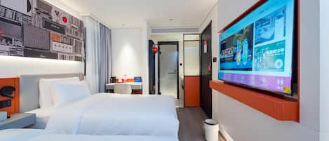 A hotel room with a large bed, a desk, and a TV mounted on the wall displaying a menu.