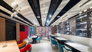 A modern restaurant with high ceilings, perforated panels, and motivational quotes on the walls. - Ibis Hotel (Beijing)