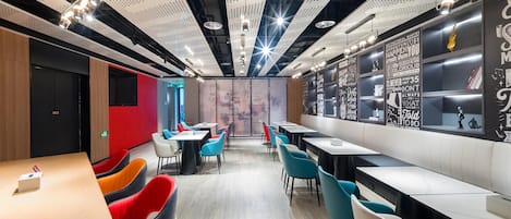 A modern restaurant with high ceilings, perforated panels, and motivational quotes on the walls.