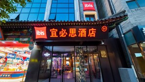A hotel entrance with a traditional Chinese architectural style, a modern glass facade, and a prominent 'ibis' sign. - Ibis Hotel (Beijing)