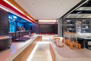 A modern kitchen with a long counter, red pots, and a chalkboard with motivational quotes. - Ibis Hotel (Beijing)
