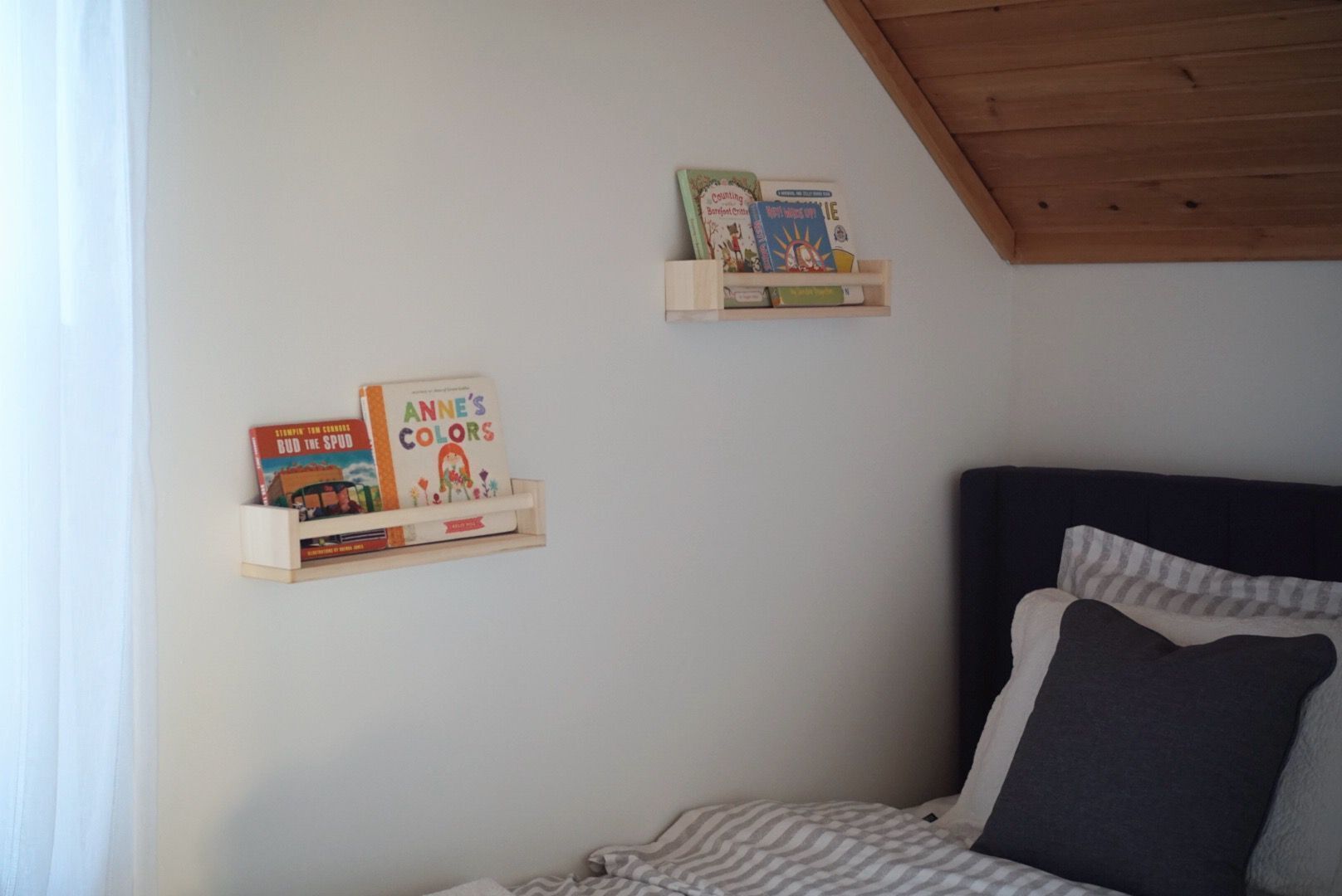 A bedroom with a bed, a pillow, and two bookshelves with books.