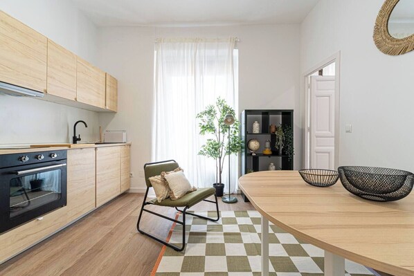 Una cocina moderna con armarios de madera, estufa negra y piso a cuadros.