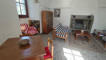 Ein gemütliches Wohnzimmer mit einem Holzesstisch, einem gestreiften Sofa und einem Kamin.
