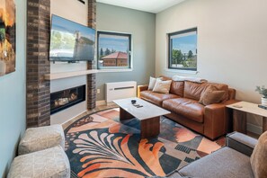 TV connectée, cheminée, livres, chaîne hi-fi